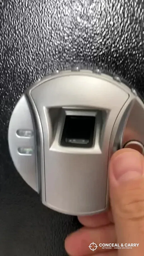 Thumb lined up on the Barska rifle safe fingerprint reader