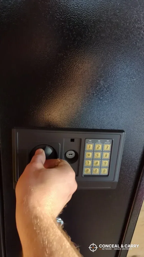 Hand turning the knob beside the BBRKIN rifle safe keypad