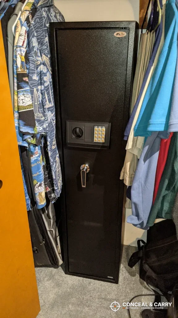 BBRKIN rifle safe in a closet with shirts hanging on both sides