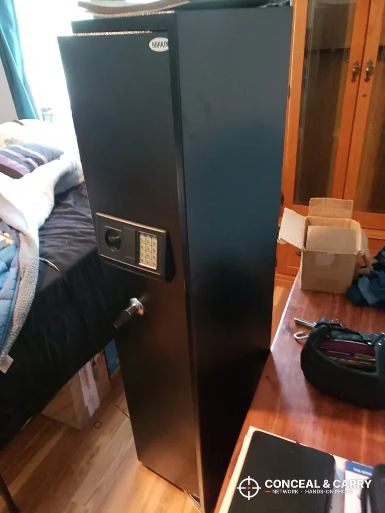 BBRKIN rifle safe standing upright beside a bed