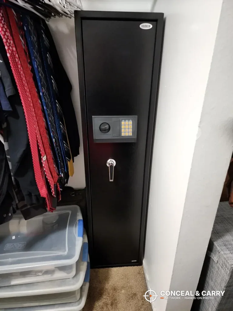 BBRKIN 5-6 gun rifle safe closed in a closet, front view with keypad and handle