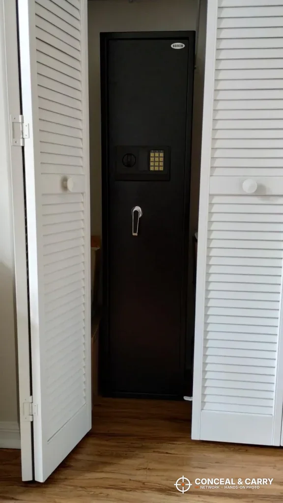 BBRKIN rifle safe standing in a closet between open white louvered doors