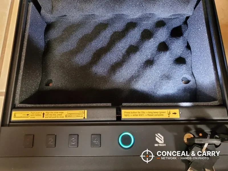 BE-TECH biometric pistol lock box open with egg-crate foam, lit fingerprint ring and keys in the lock