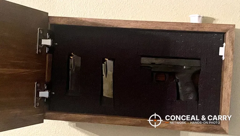 Bellewood hidden gun safe sign open on the wall with a pistol and two magazines in the foam