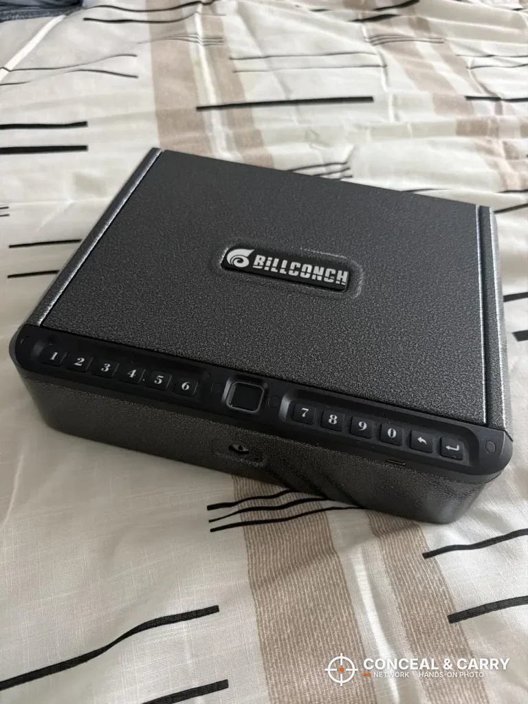 BILLCONCH biometric handgun safe closed on a bed, front corner view