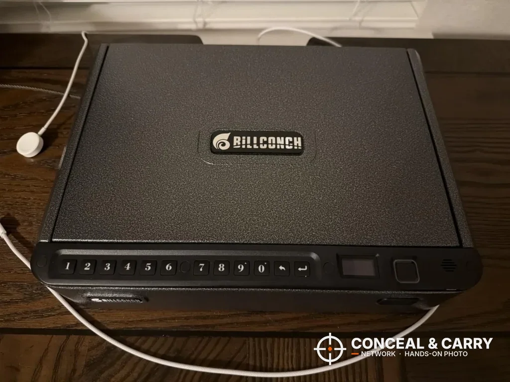 BILLCONCH handgun safe on a wood table with a white cable beside it
