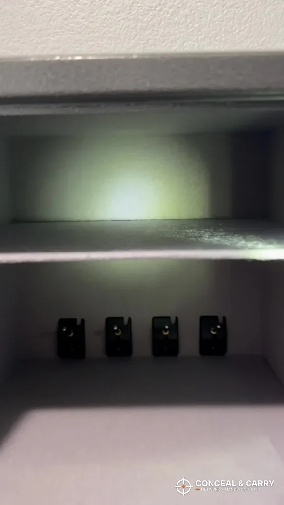 Billconch multi-pistol safe interior with the LED light on, shelf and four bracket posts