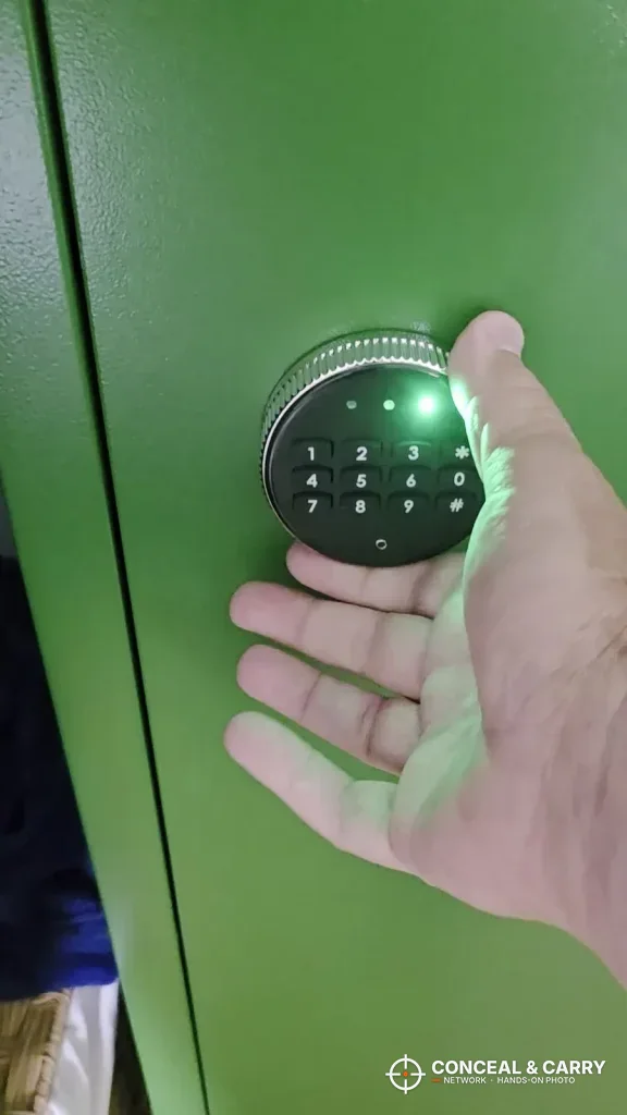 Round Bonusall gun safe keypad lit green on a green cabinet door