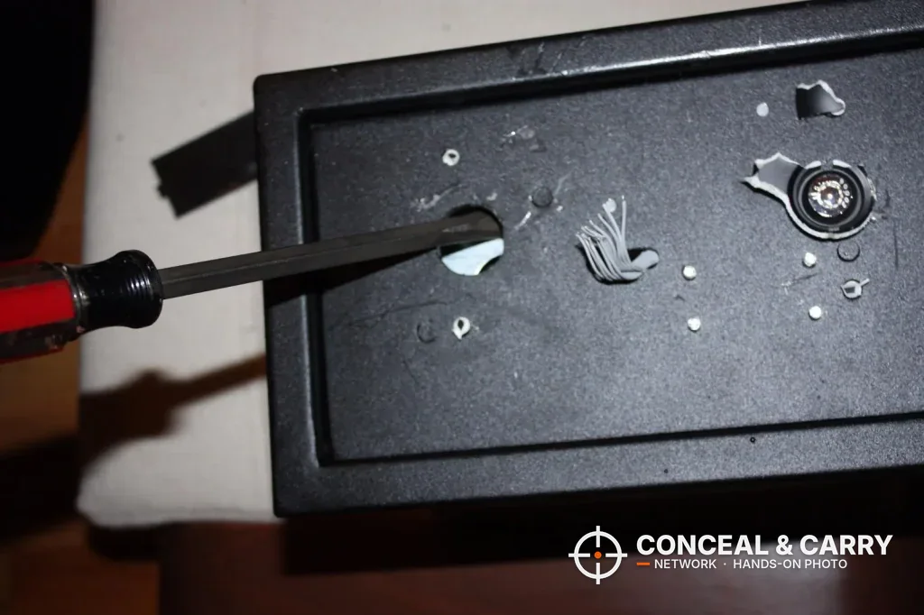 Screwdriver in a hole in the Bulldog BD1050 door panel with the keypad off
