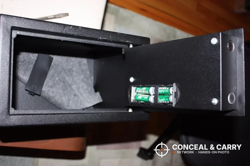 Battery holder on the inside of the Bulldog BD1050 door with the carpeted floor behind it