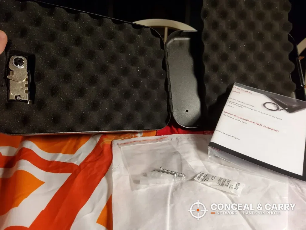 Dalmbox lock box open with foam lining, instruction card and bagged cable