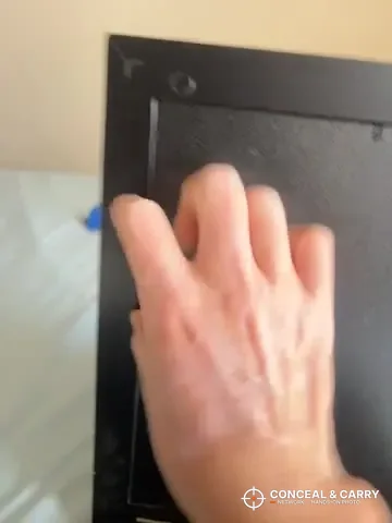 Hand on the plain back panel of the Dononr hidden storage frame
