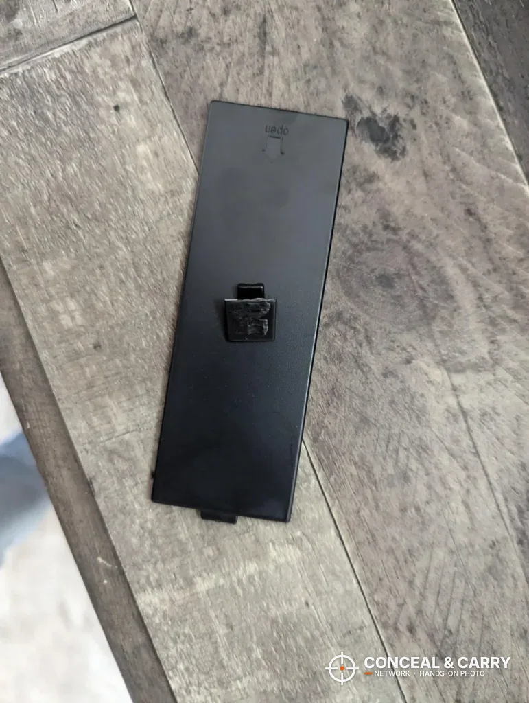 Loose black panel from the EMAXEE gun cabinet lying on a table