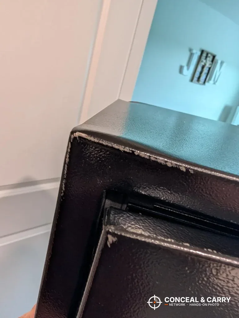 Scuffed paint along a top corner of the EMAXEE gun cabinet