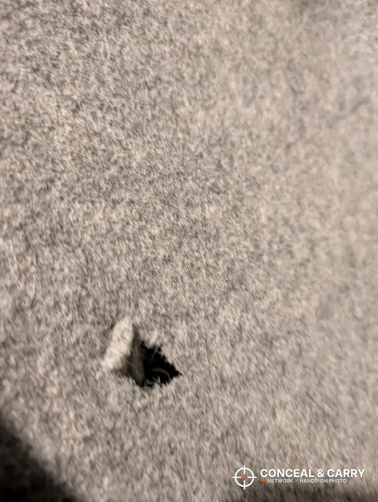 Close-up of a small hole in the EMAXEE cabinet's felt lining