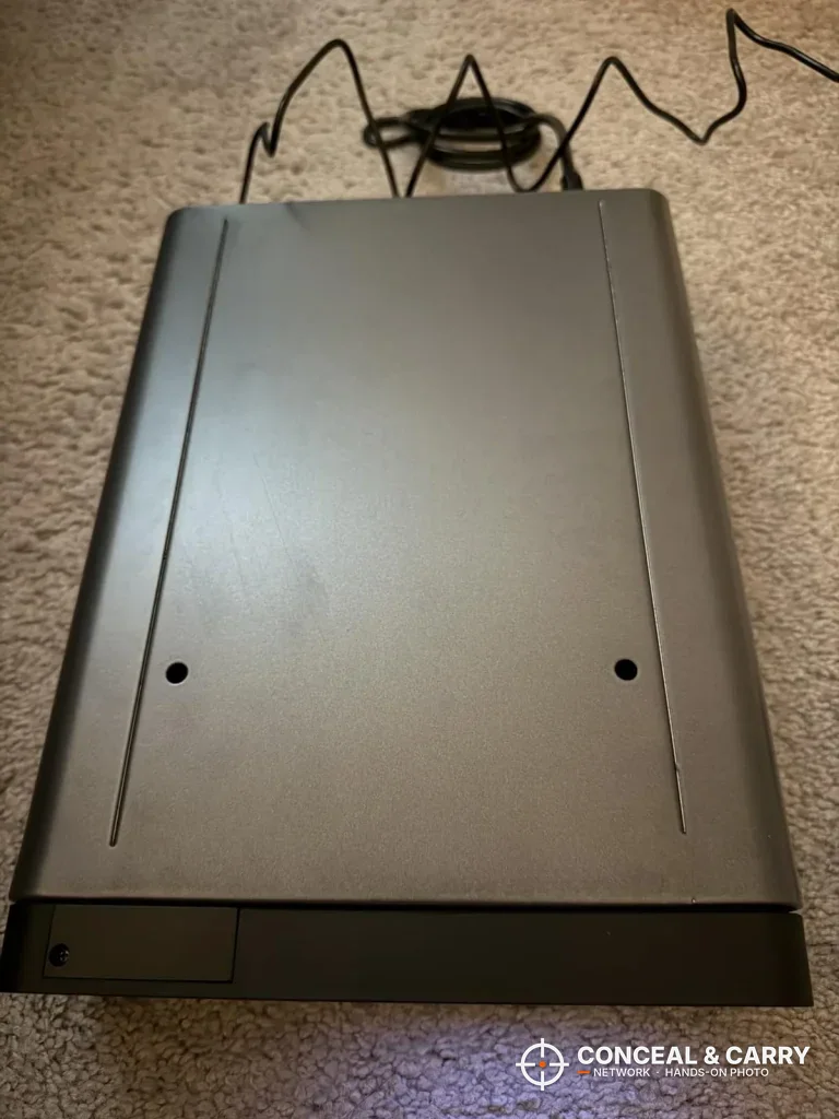Underside of the FTOP clock gun safe with two round holes and the power cord