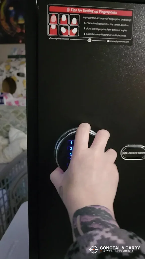 Hand reaching to the Grimtron 4-pistol safe keypad and fingerprint reader from the side