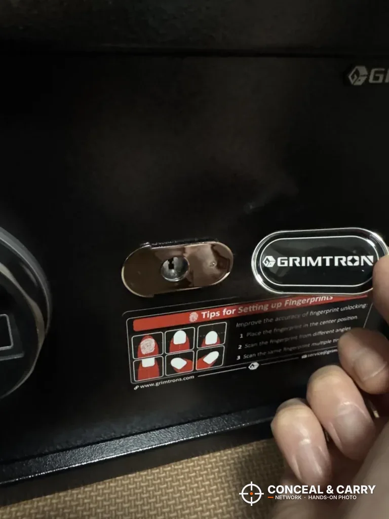 Key lock on the front of the Grimtron 4-pistol safe beside the badge