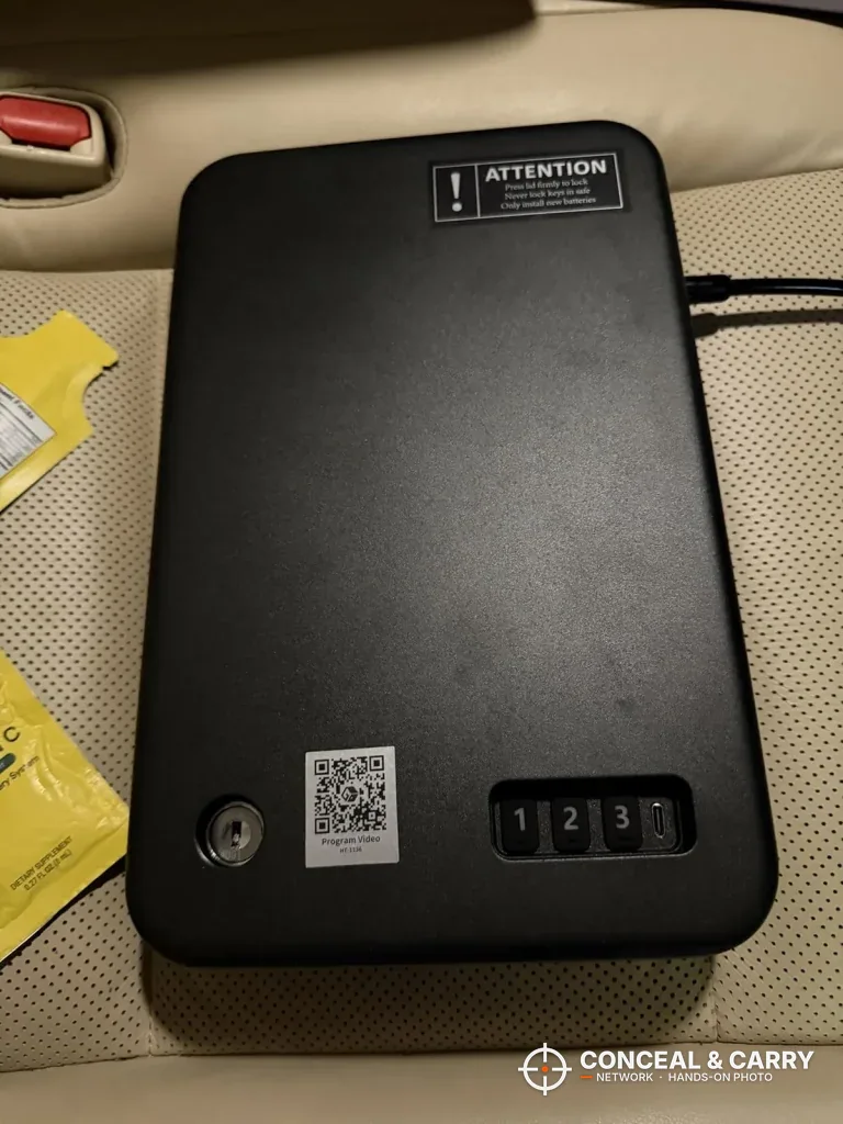 Grimtron portable car gun safe on a car seat with cables running off the side