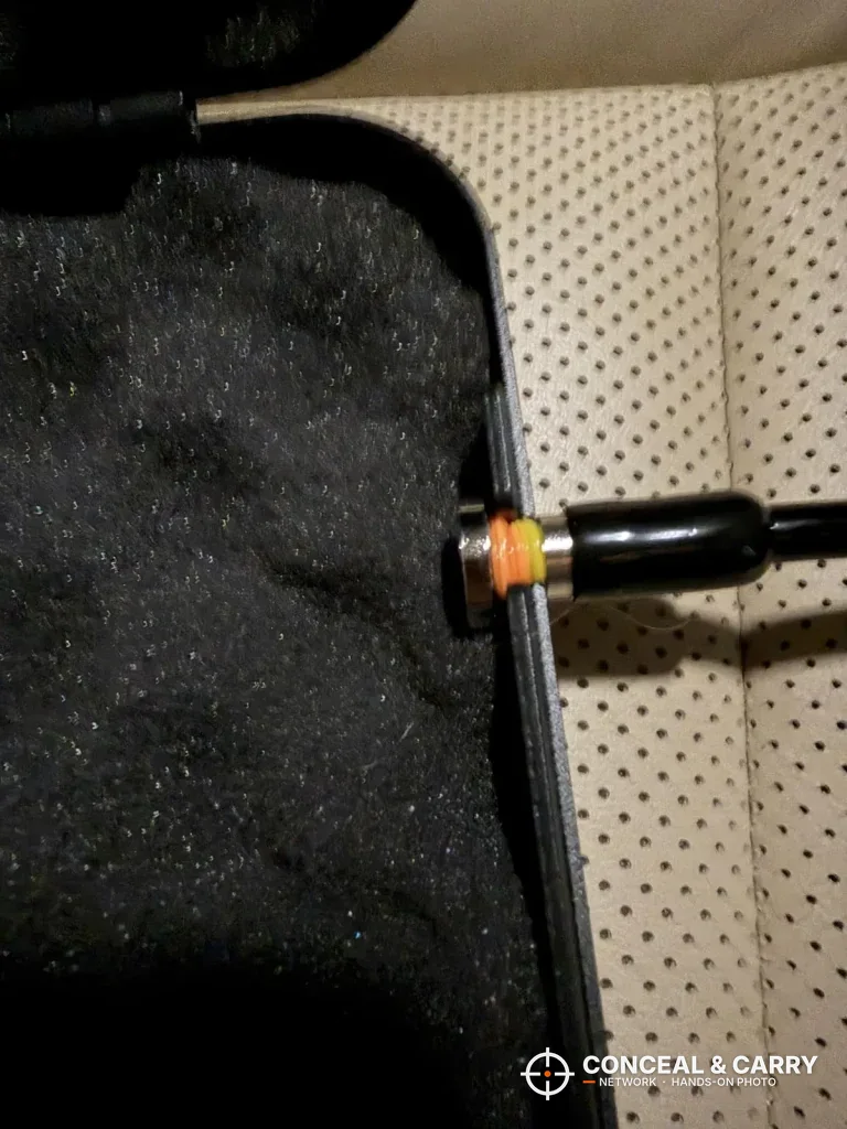 Close-up of a cable at the edge of the Grimtron car gun safe on a car seat