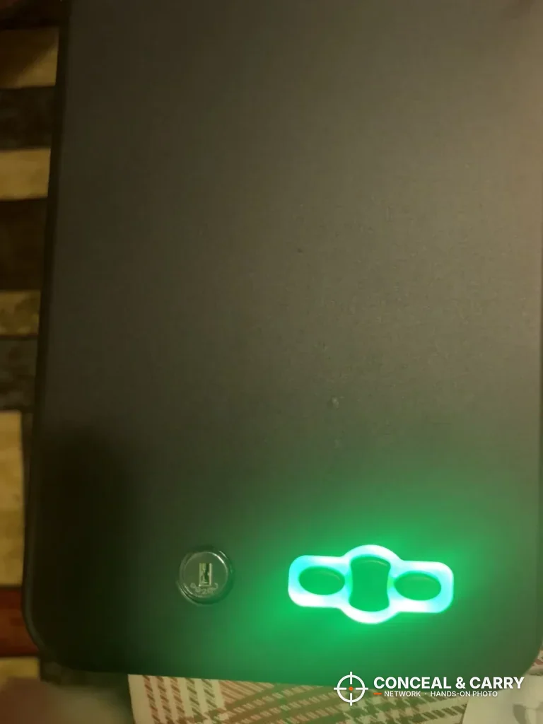 Grimtron car gun safe keypad glowing green in low light beside the key lock
