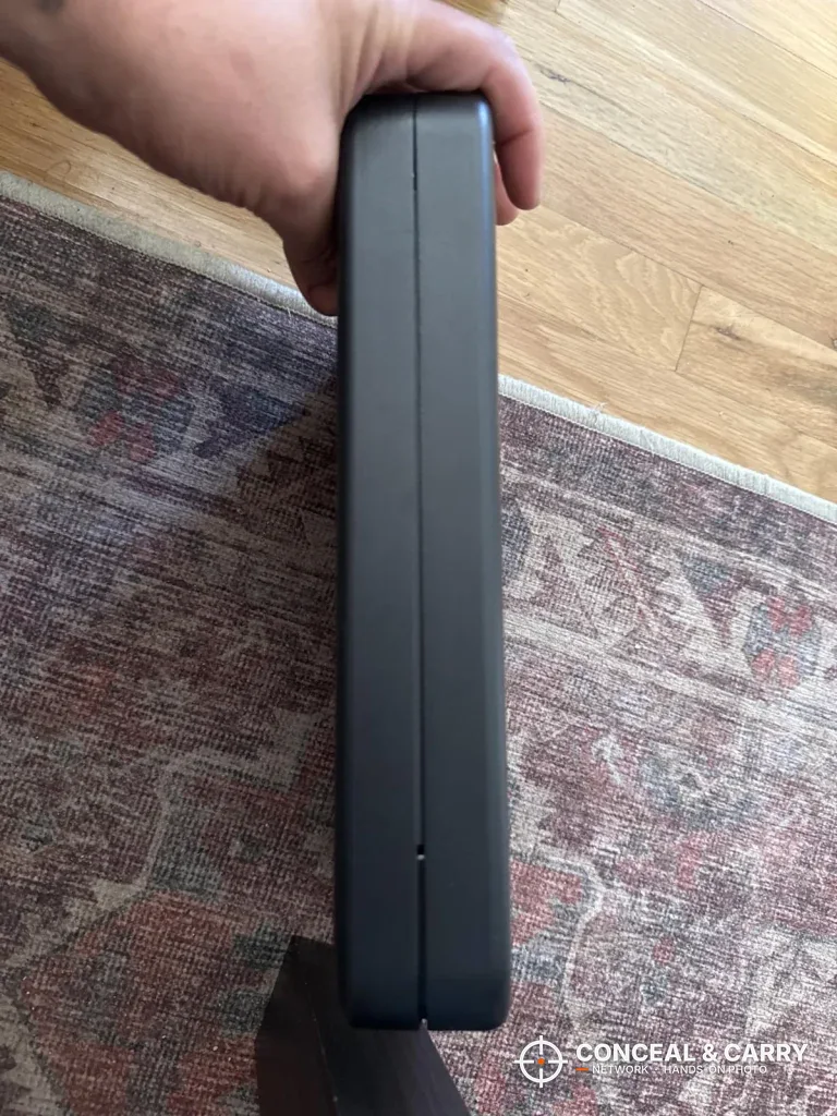 Grimtron portable car gun safe held edge-on to show how thin it is