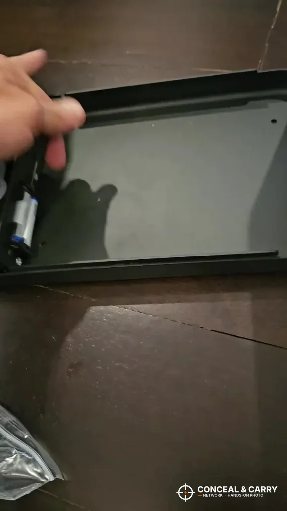 Lid of the Grimtron portable car gun safe lifted open by hand