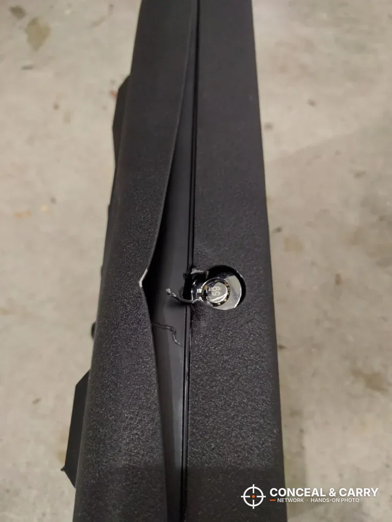 Side edge of a GunVault MV500 with the key lock and a bent seam