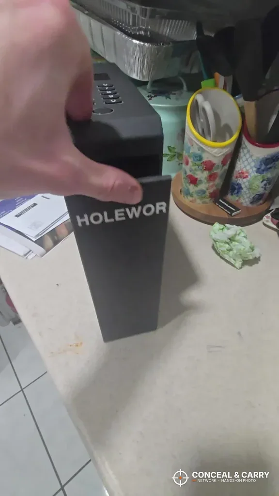 Hand on top of the upright HOLEWOR slider safe on a counter