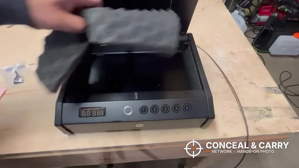 Hand lifting the foam pad out of the HOLEWOR handheld safe