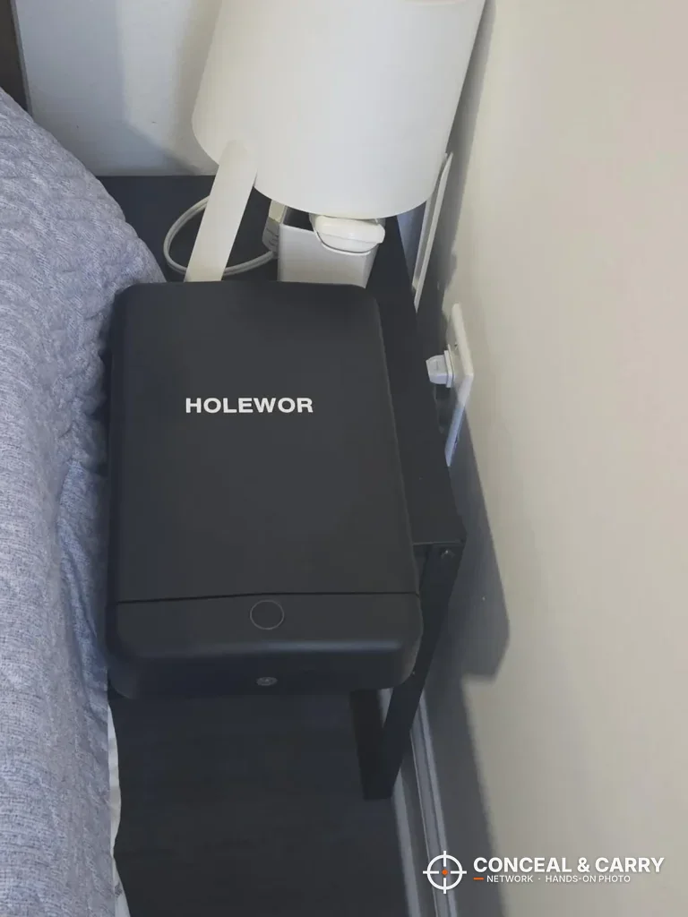 HOLEWOR small biometric lock box on a nightstand beside a bed