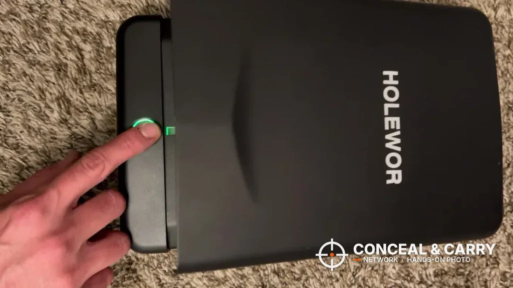 Finger on the HOLEWOR lock box fingerprint reader with the green light on