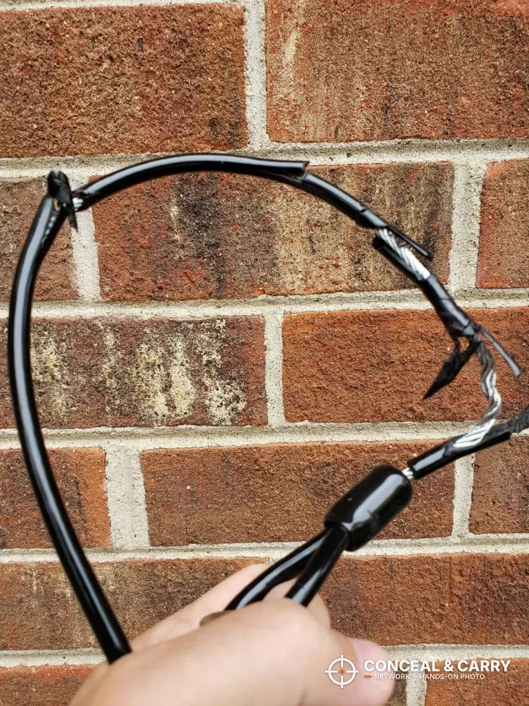 Cut Hornady Lockbox cable held up against a brick wall