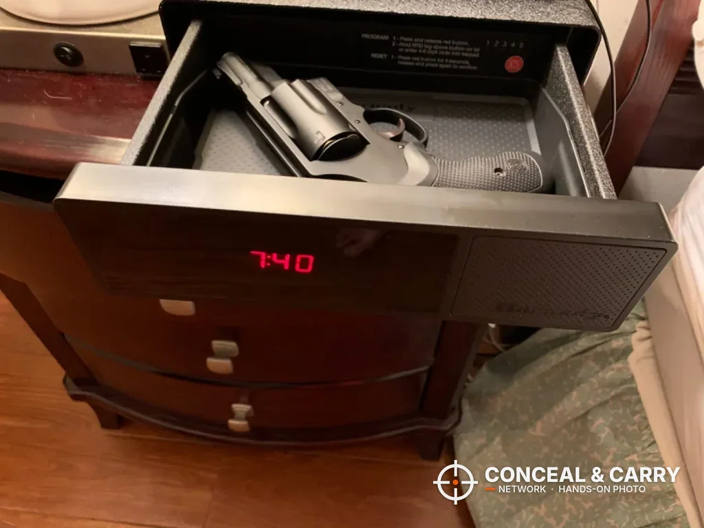 Hornady RAPiD Safe Night Guard drawer open with a revolver inside and the clock lit, on a nightstand