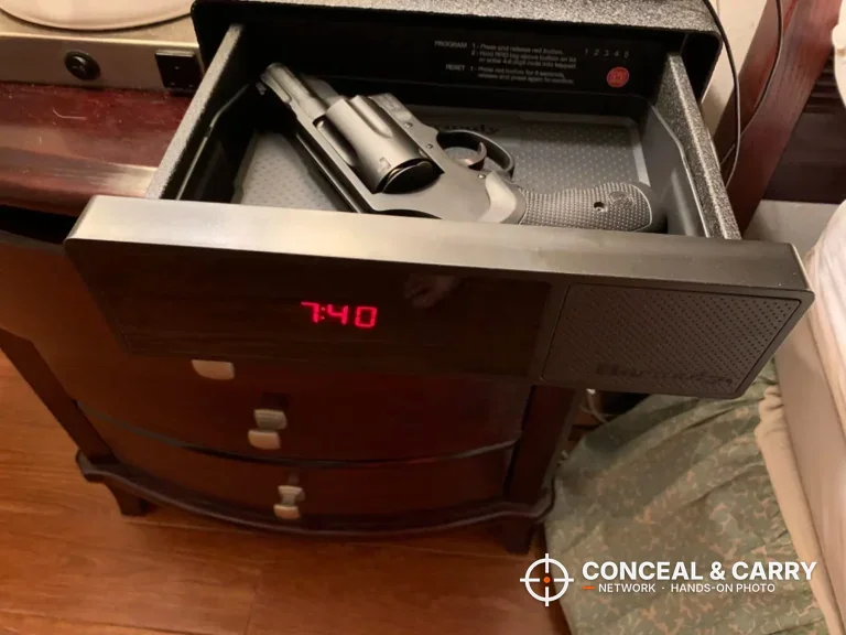 Hornady RAPiD Safe Night Guard drawer open with a revolver inside and the clock lit, on a nightstand