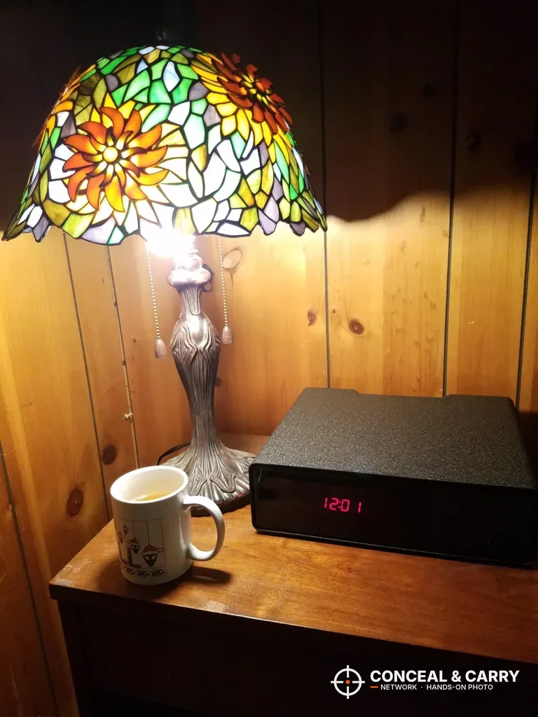 Hornady Night Guard beside a stained-glass lamp and a coffee mug at night