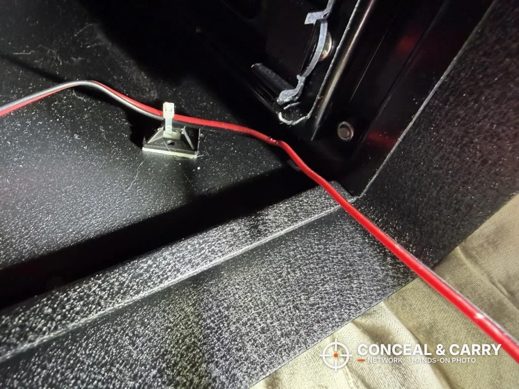 Inside the Hornady Night Guard housing with the drawer out and a red and black wire along the steel