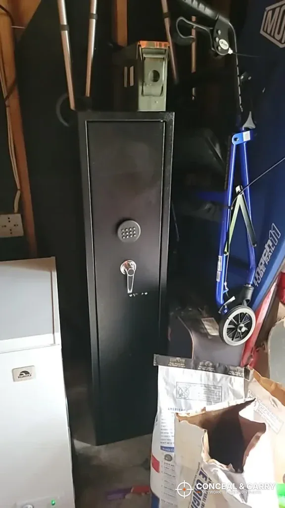 INTERGREAT gun cabinet standing in a cluttered storage area