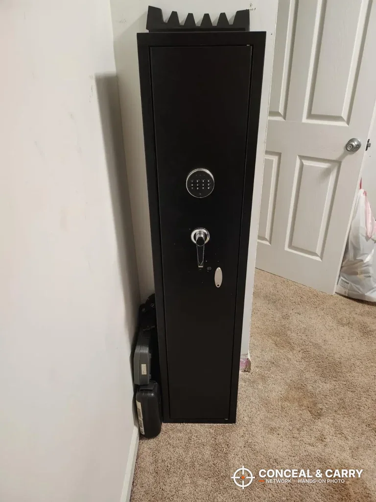 INTERGREAT long gun cabinet standing in a room corner beside a door