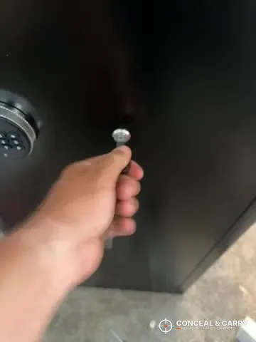 Hand at the key lock on the INTERGREAT long gun cabinet door