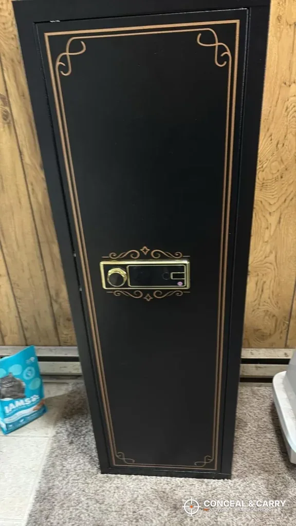 KAER 12-15 gun biometric cabinet with gold trim standing against wood paneling