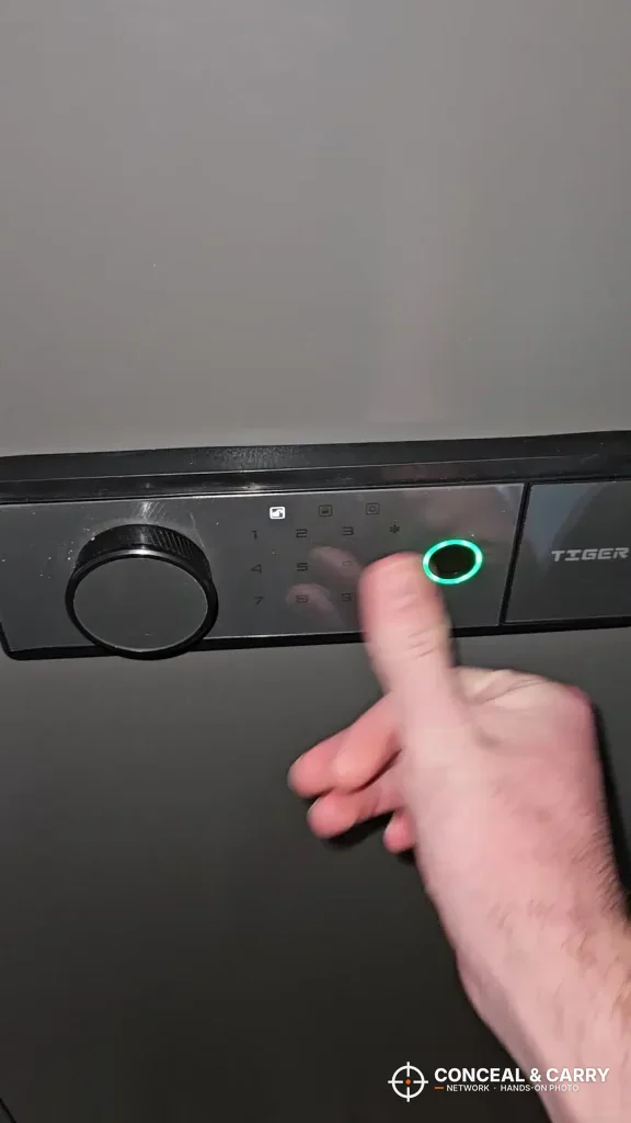 Finger on the KAER 18-21 gun safe fingerprint reader with its green ring lit