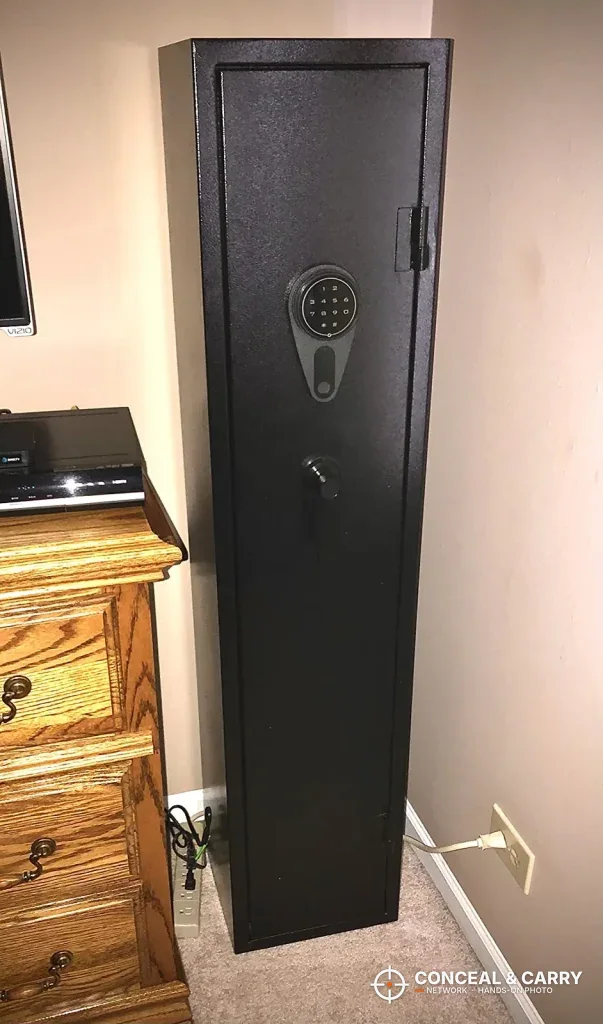KAER 3-gun rifle safe standing closed in a bedroom corner beside a dresser