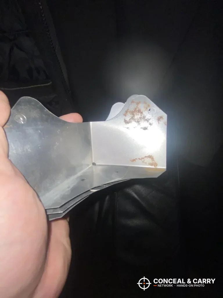 Hand holding a metal bracket from the KAER 3-gun rifle safe