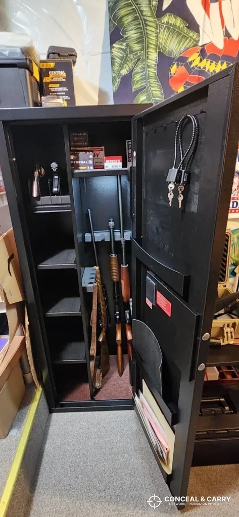KAER 8-12 gun cabinet open with long guns in the rack and gear on the door