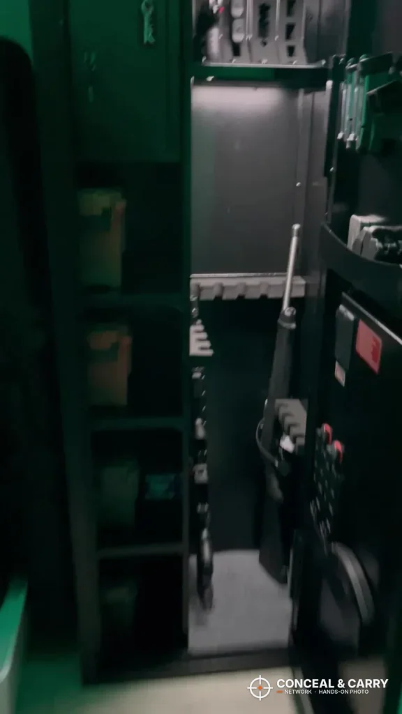 Green-lit view into the KAER 8-12 cabinet with gear on the side shelves