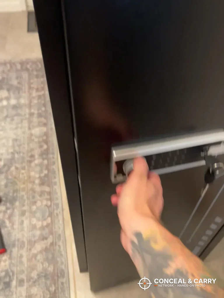 Hand pulling the KAER 8-12 cabinet door open by the lock panel