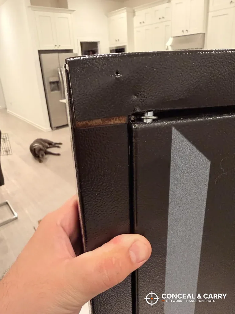 Hand holding the edge of the open KAER 8-12 cabinet door