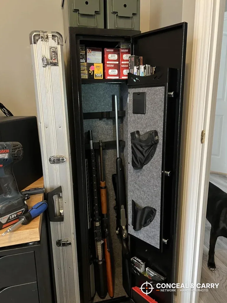 KAER electronic long gun safe open in a closet with long guns, ammunition and the door organizer