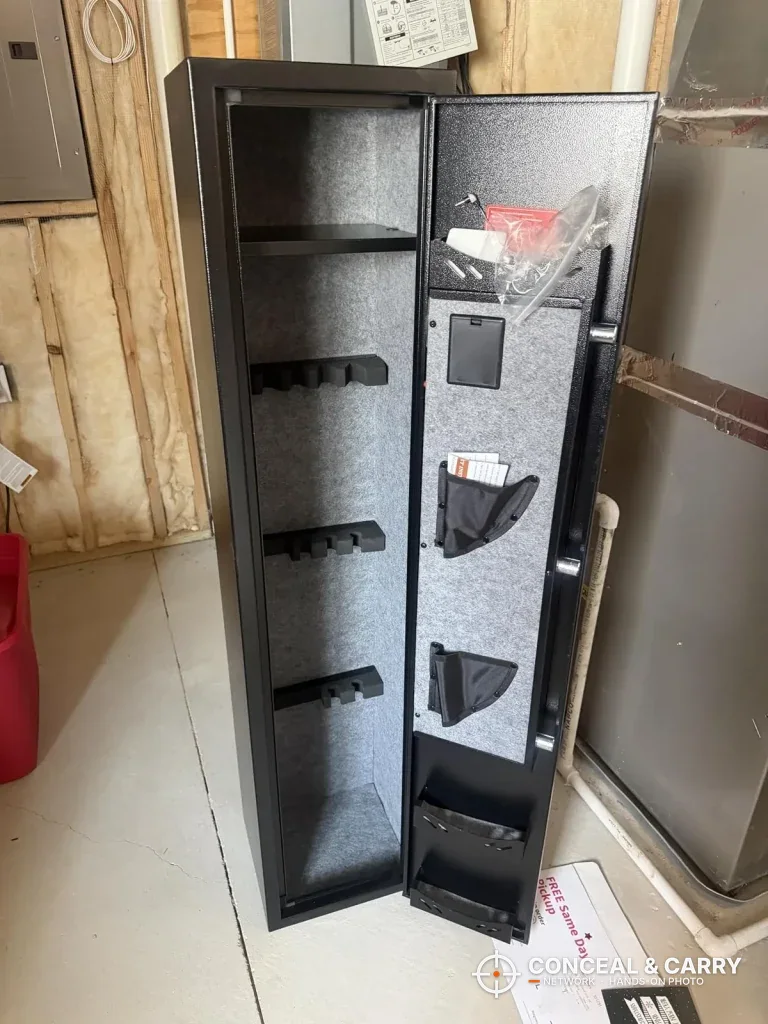 KAER long gun safe open and empty, with notched racks on the back wall and a top shelf